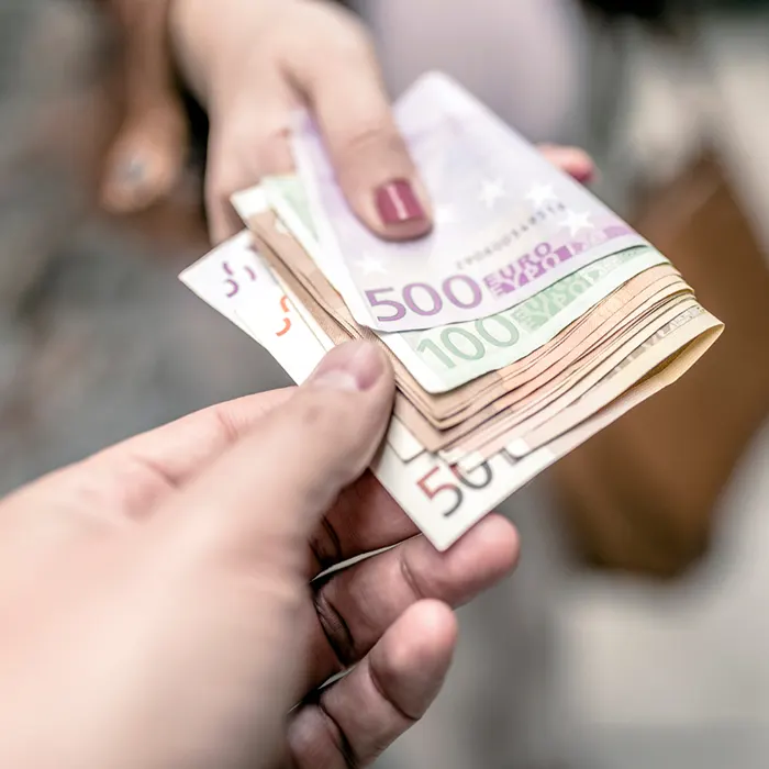 a lady giving foreign currency euro to other