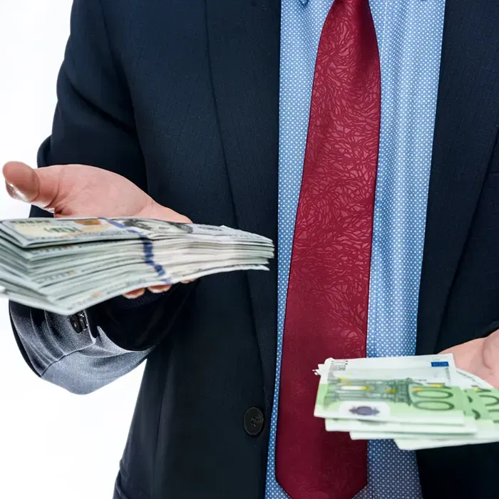a man in suit holding foreign currencies dollar on both hands