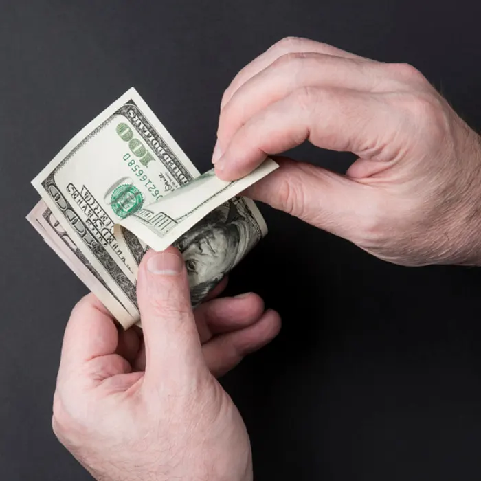a person holding a stack of foreign currency